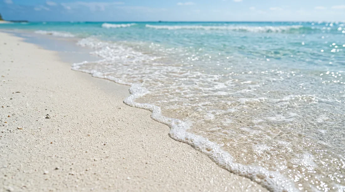 Gros plan sur le sable blanc et l'eau turquoise d'un lagon