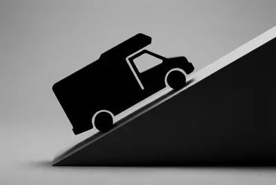 Icône de camping-car en difficulté sur une pente raide