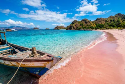 Plage de sable rose et bateau traditionnel à Komodo