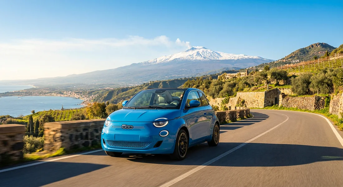 Voiture de location sur une route pittoresque en Sicile avec l'Etna au loin.